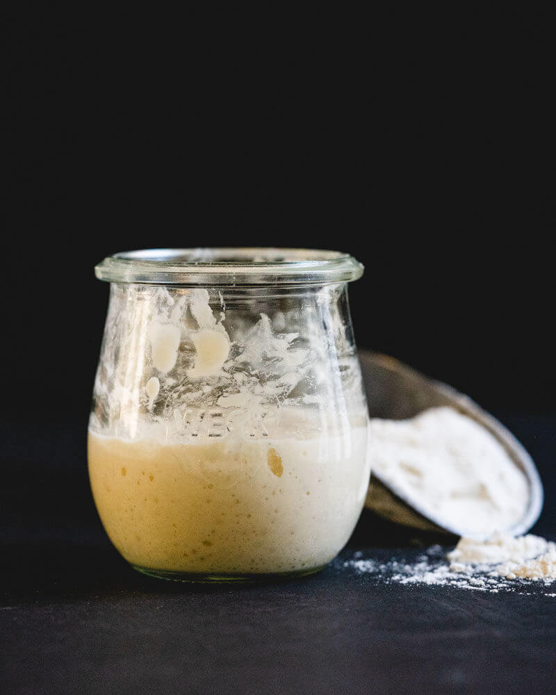 sourdough starter in a jar with flour